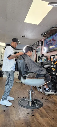 Barber cutting a client's hair in the barber chair at Faded